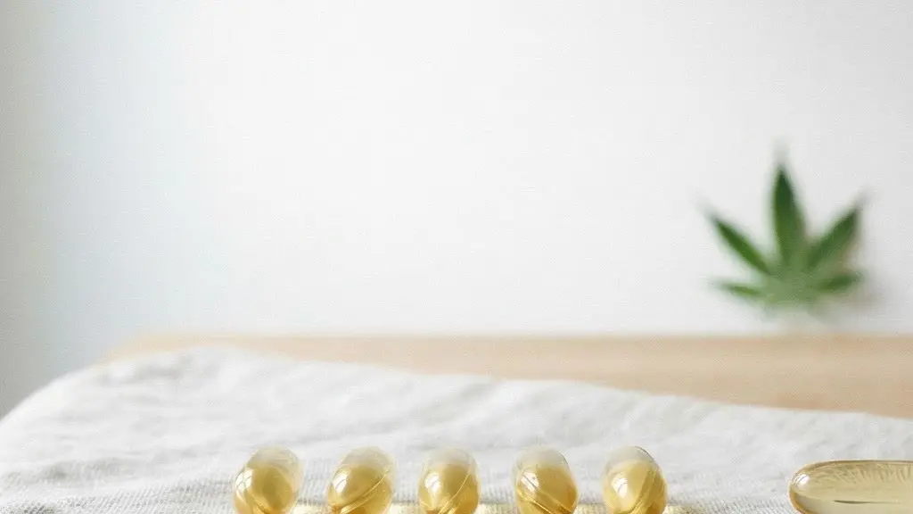 Vue large et épurée de capsules molles dorées alignées sur une surface claire dans un environnement minimaliste baigné de lumière naturelle, symbolisant la pureté et le choix éclairé.