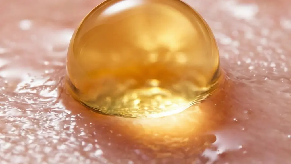 Vue macroscopique artistique d'une goutte d'huile dorée se diffusant sur une surface texturée rappelant une membrane biologique.